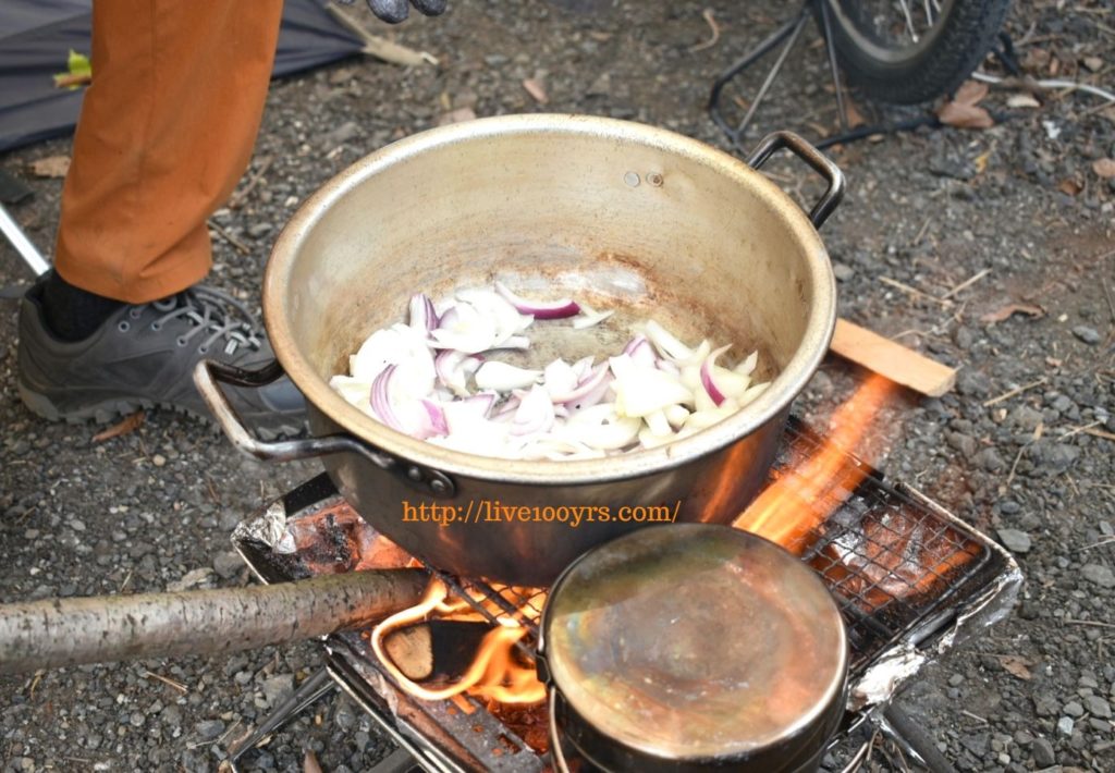 キャンプでカレー作り、たまねぎを炒め始めます