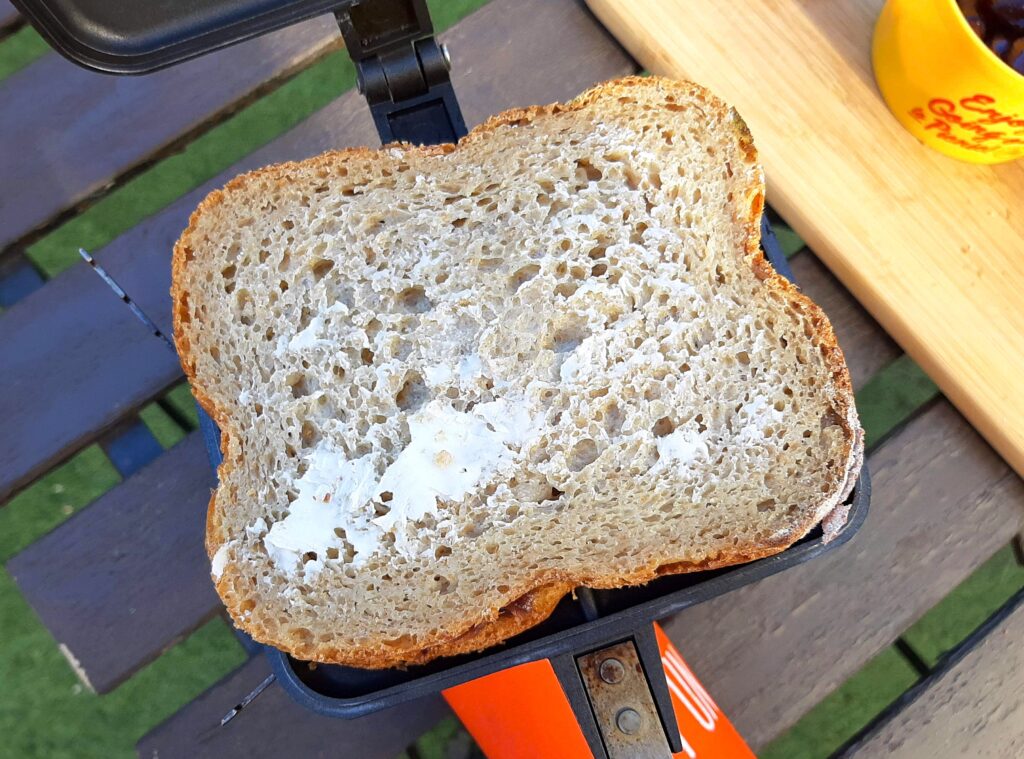 ホットサンドメーカーにパンをのせて、上のパンにバターを塗ります